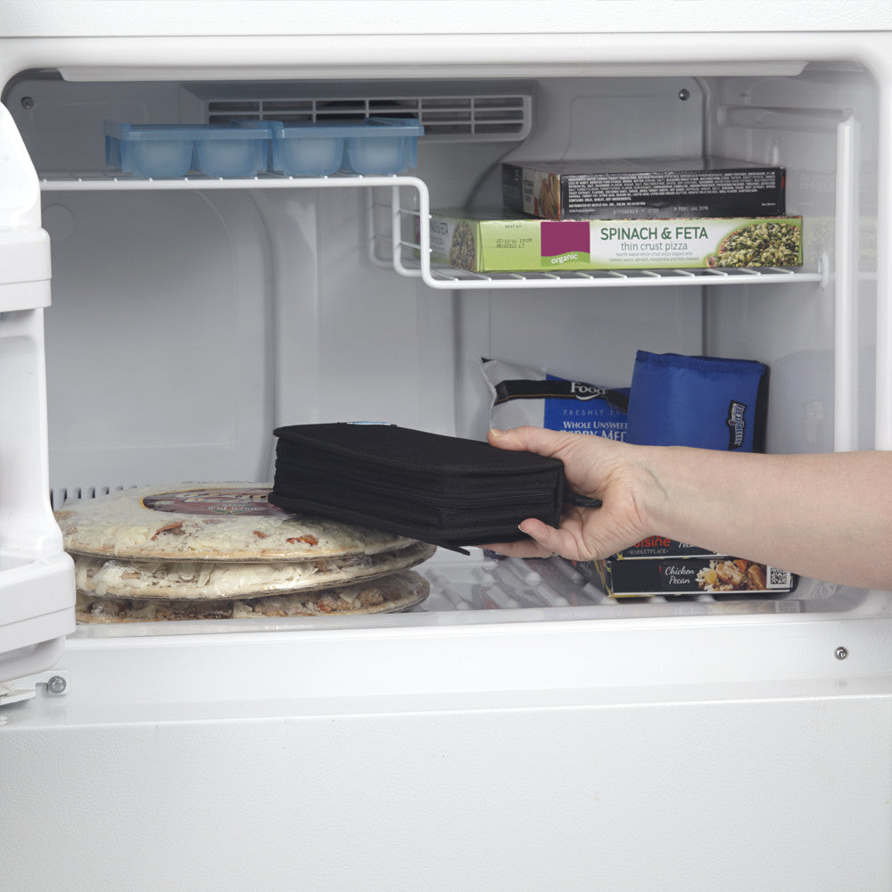 Hand placing folded FlexiFreeze refreezable breastmilk pocketbook cooler, black, into freezer