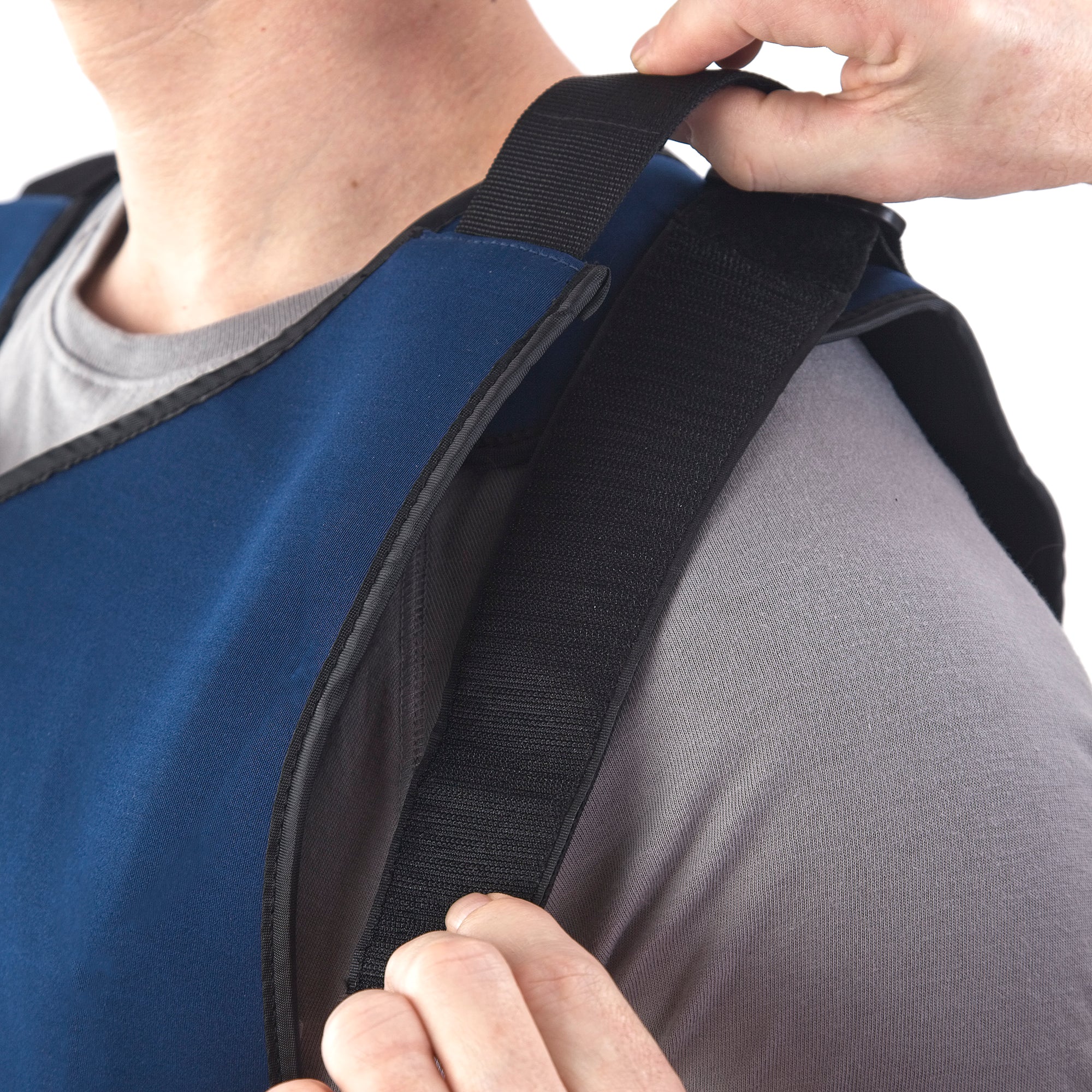Man wearing FlexiFreeze personal ice vest, adjusting shoulder strap, blue