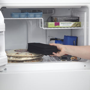 Hand placing FlexiFreeze refreezable medicine cooler, black, into freezer