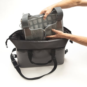 Hand placing FlexiFreeze professional ice vest, into FlexiFreeze insulated tote bag, large, gray